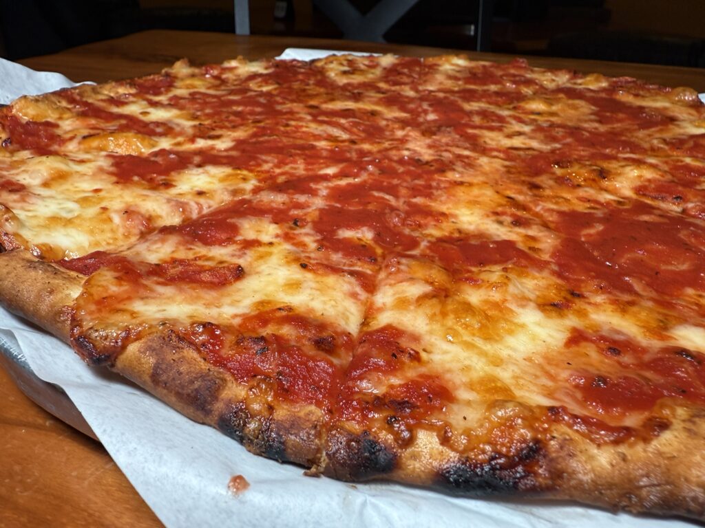 Sabatini's large pizza with their signature sauce on top of the cheese